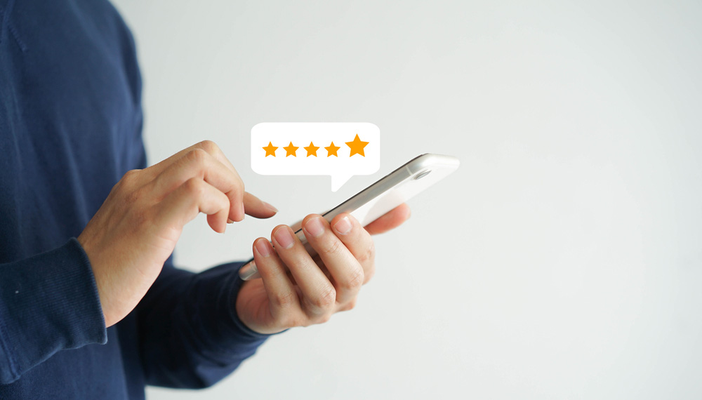 customer man hand pressing on smartphone screen with gold five star rating feedback